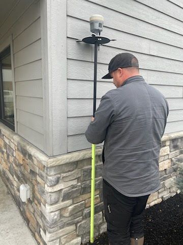 Survey crew using GNSS equipment on residential jobsite with protective gear